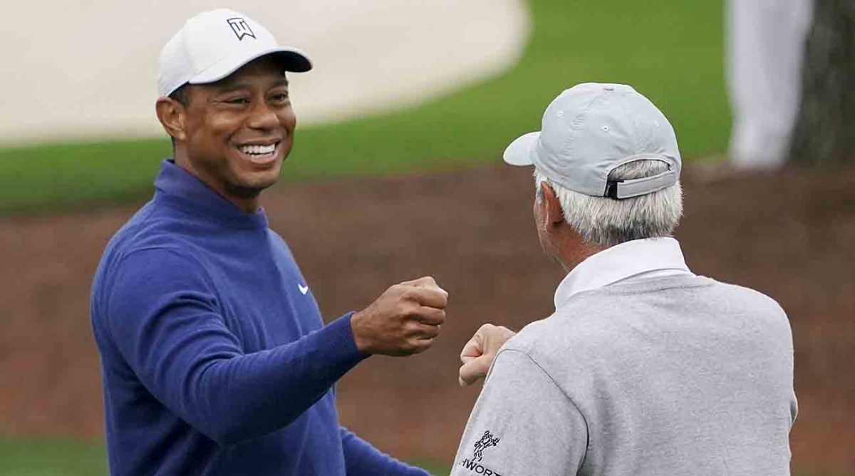 Tiger Woods gives Fred Couples a fist bump during a 2023 Masters practice round.