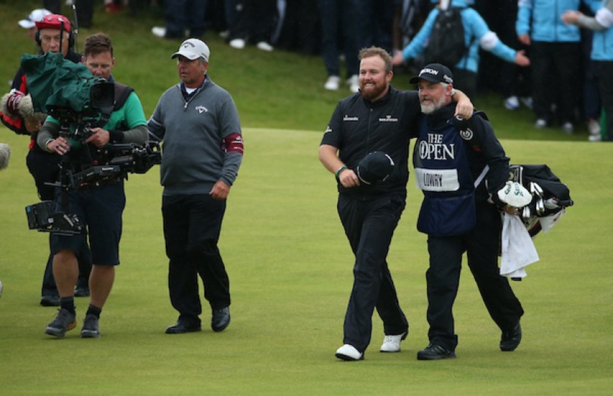 Ireland’s Shane Lowry, leading by 6 strokes on the final hole, celebrates early with caddie Brian Martin as they walk the 18th fairway Sunday at Royal Portrush in Northern Ireland.