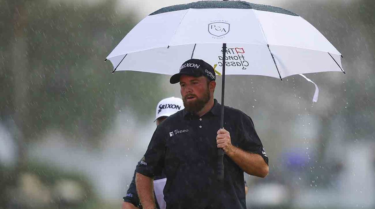 Shane Lowry holds an umbrella on the 18th hole in the final round of the 2022 Honda Classic.