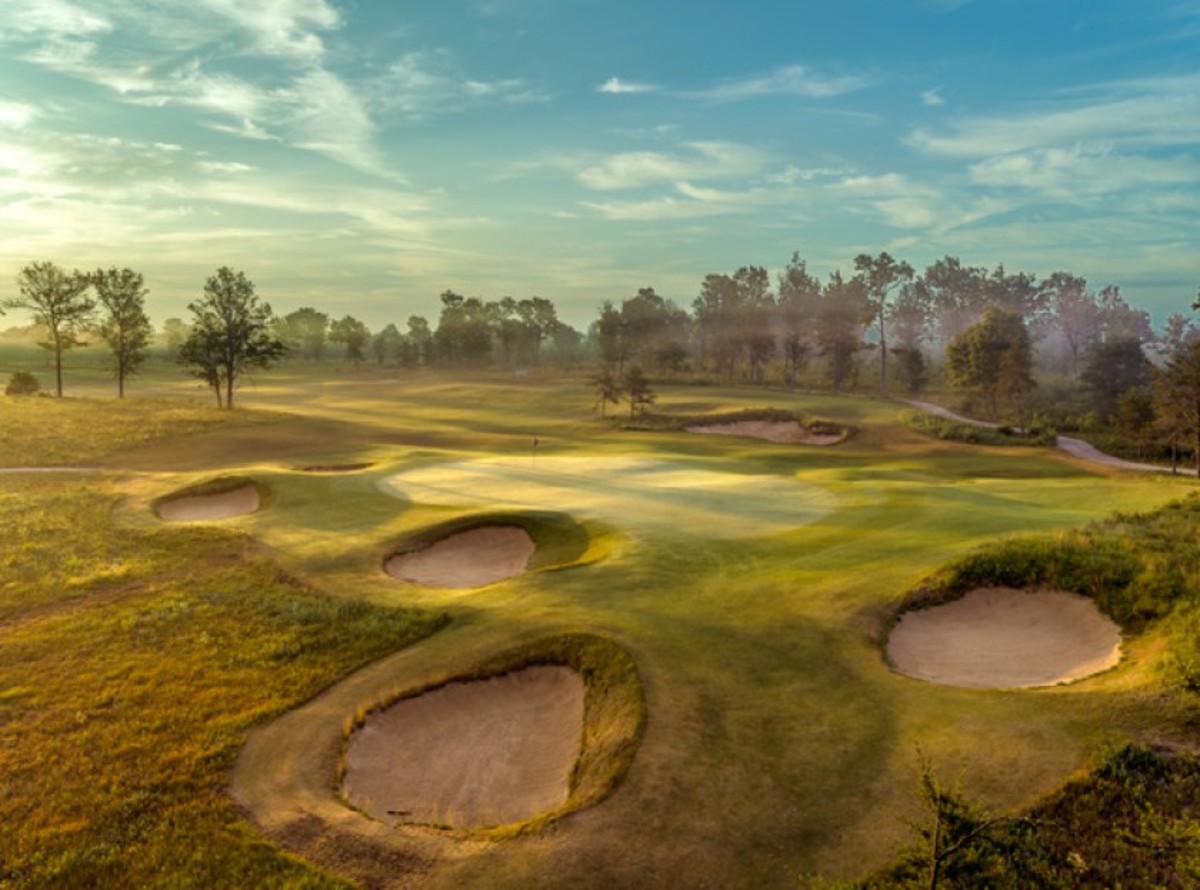 A surreal early morning fog envelopes a green that serves as The Loop reversible course's 12th (Black Course) and sixth (Red Course) green. The Tom Doak-designed course is part of Forest Dunes Golf Club in Roscommon, Mich.