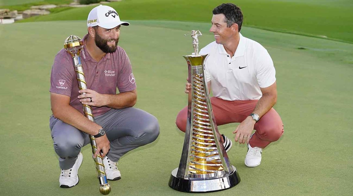 Jon Rahm, winner of the 2022 DP World Tour Championship, and Rory McIlroy, winner of the 2022 DP World Tour Race to Dubai, are pictured with their respective trophies.