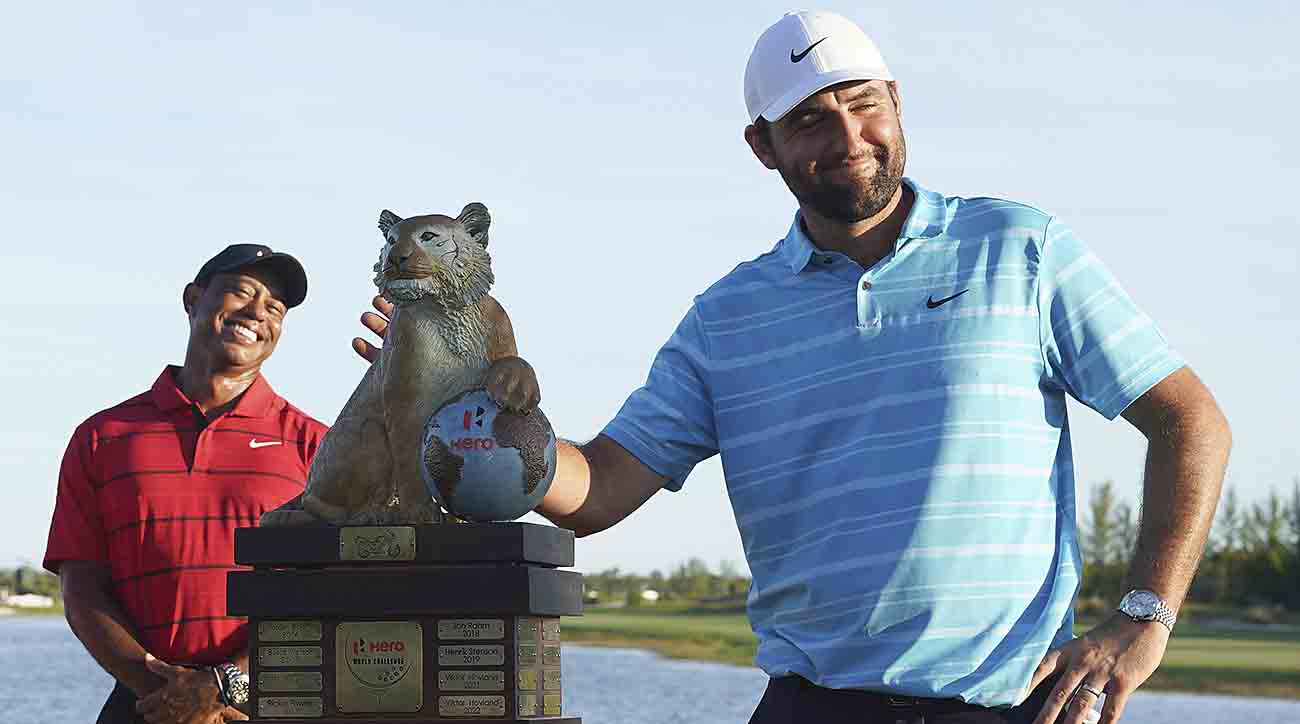 Scottie Scheffler, right, poses with the trophy as Tiger Woods smiles in the background, after winning the Hero World Challengeat the Albany Golf Club, in New Providence, Bahamas, Sunday, Dec. 3, 2023.