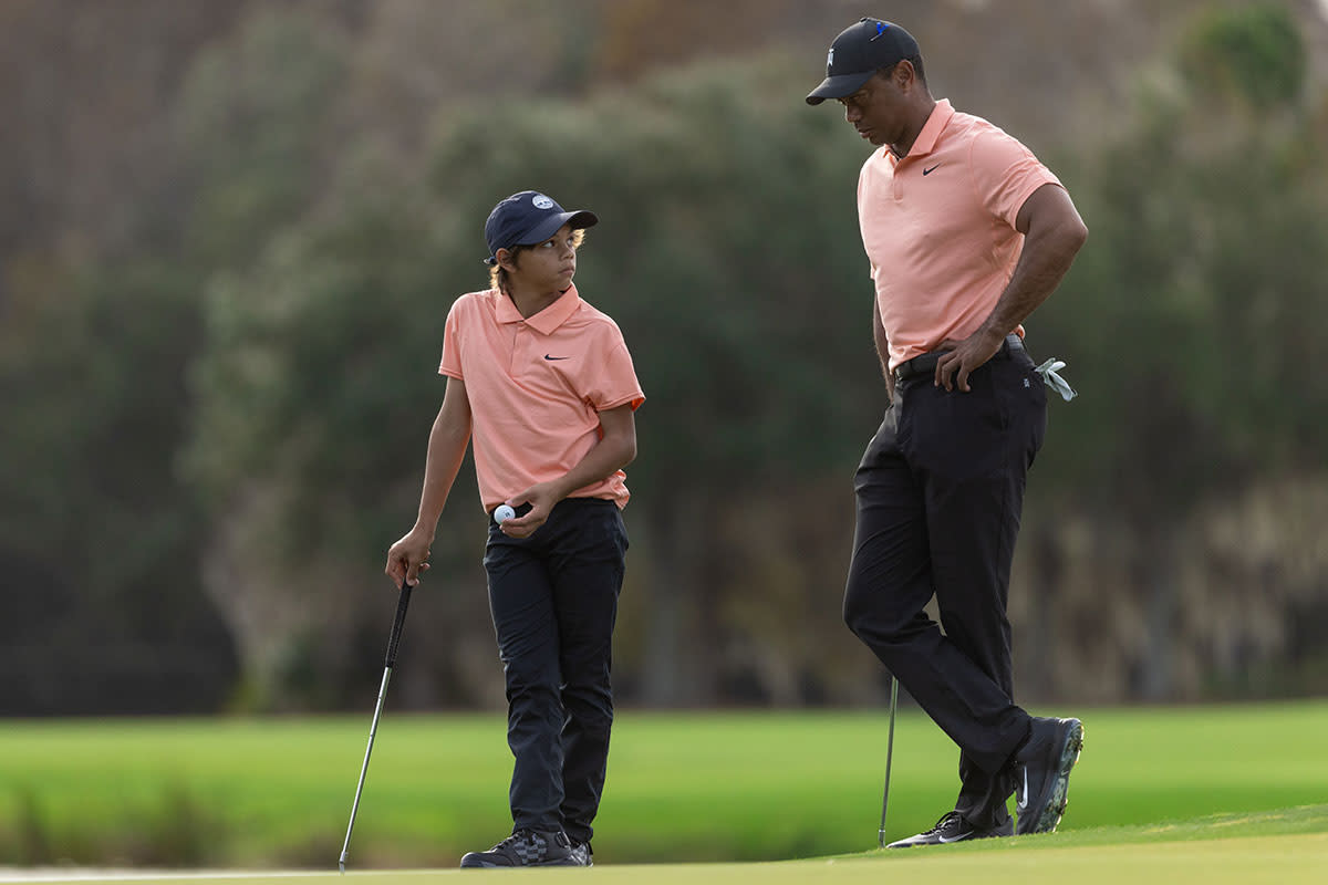 Tiger Woods and Charlie Woods talk on the 12th green.