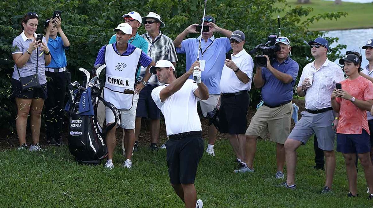 Brooks Koepka hits a shot in front of fans at the 2022 LIV Golf Team Championship.