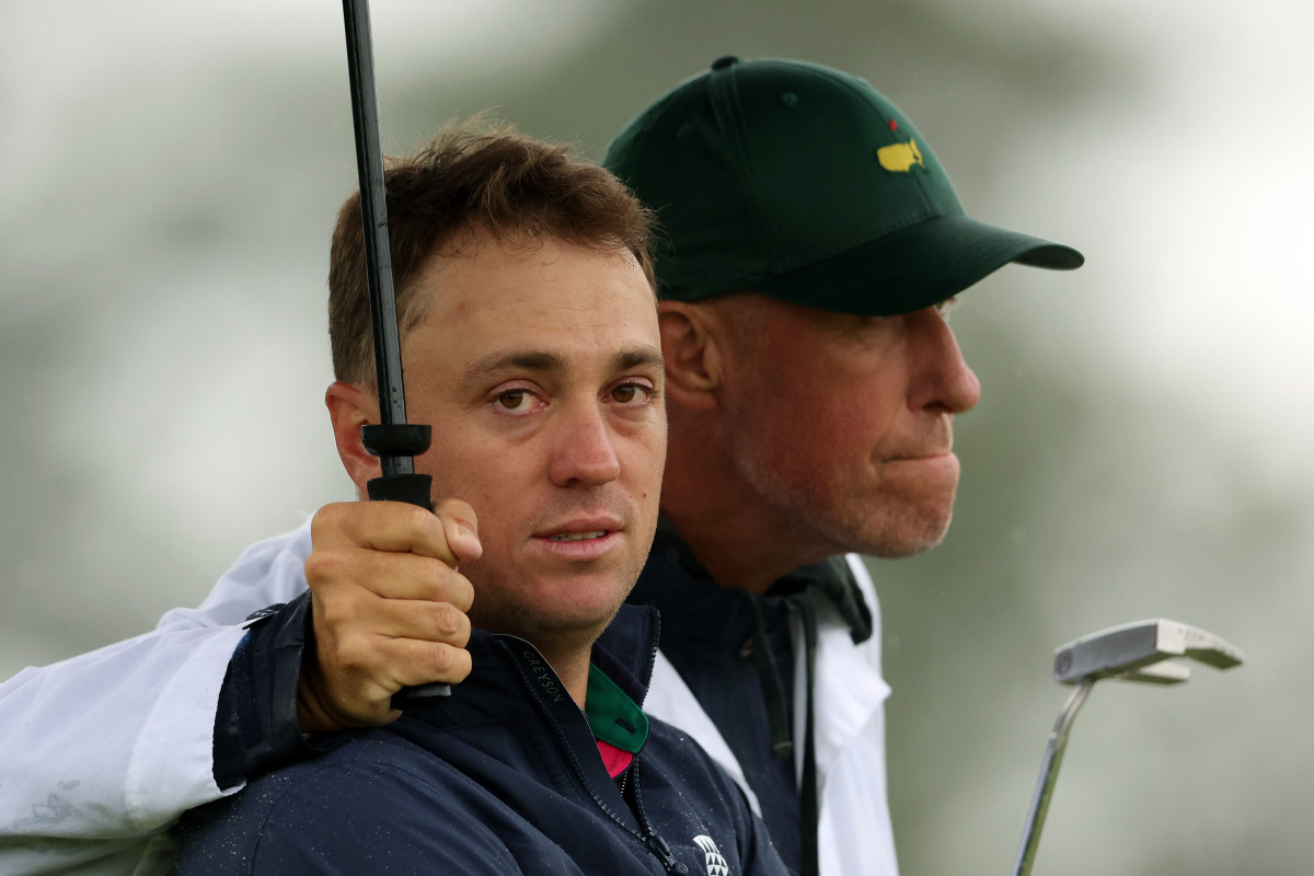 Justin Thomas of the United States and his caddie Jim 'Bones' Mackay react to his bogey on the 18th green during the continuation of the weather delayed second round of the 2023 Masters Tournament at Augusta National Golf Club on April 08, 2023 in Augusta, Georgia.
