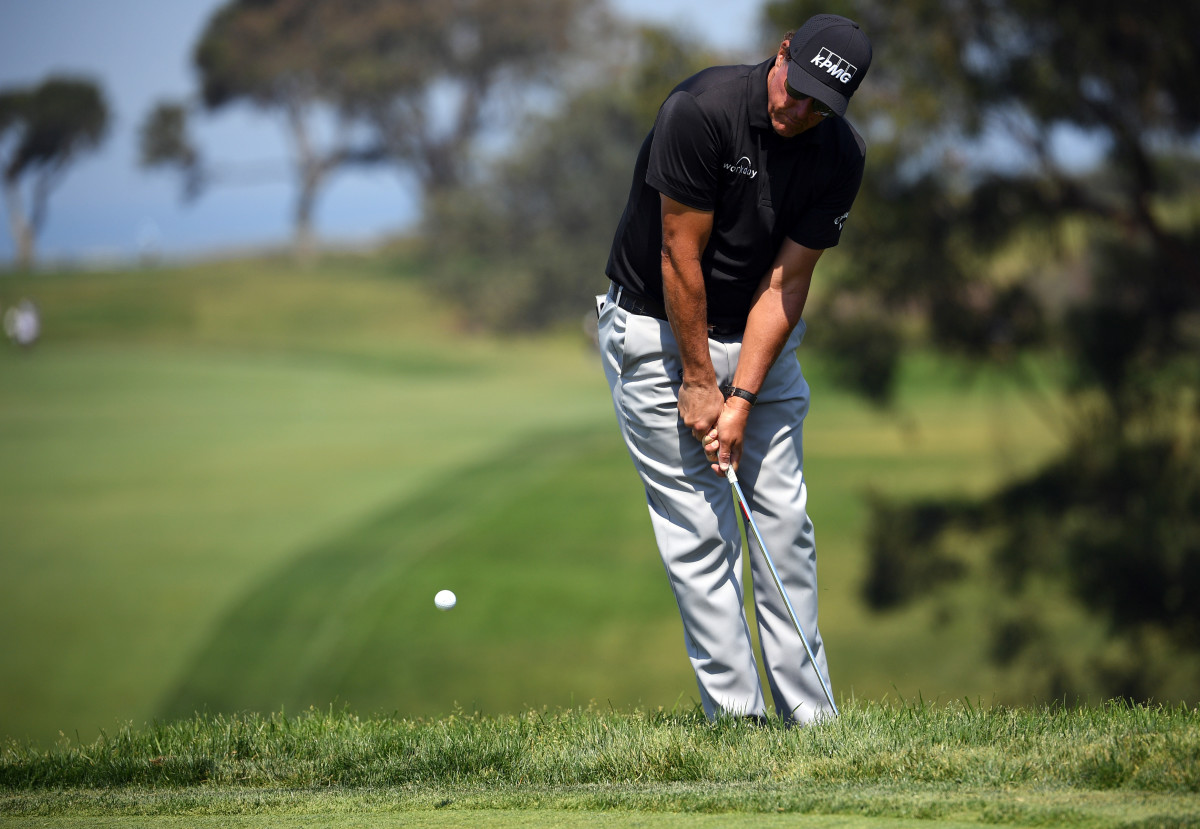 Phil Mickelson chips onto the 13th green during the U.S. Open's first round at Torrey Pines Golf Course.