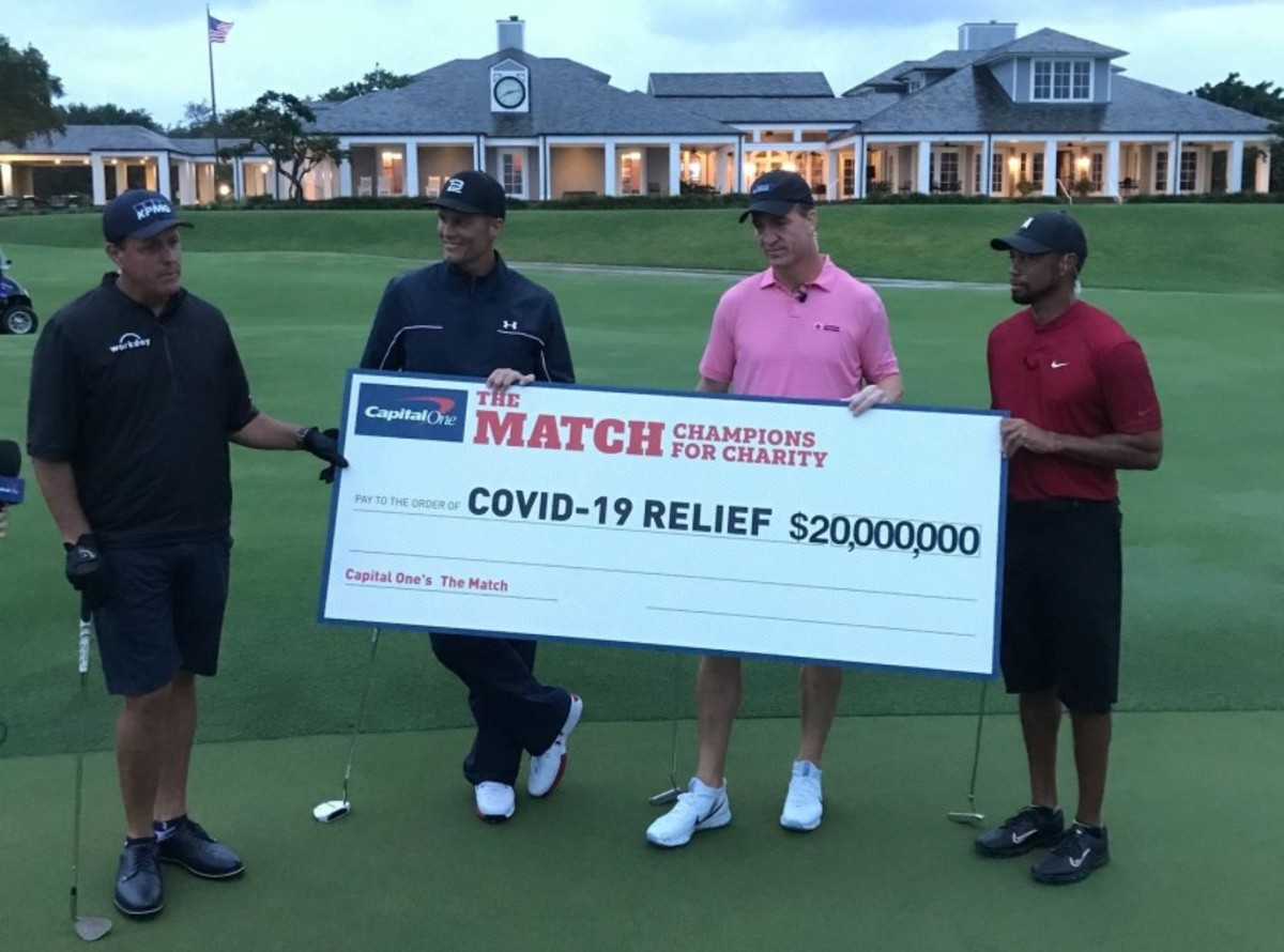 Phil Mickelson (from left) and partner Tom Brady lose to Peyton Manning and Tiger Woods, 1 up, in ‘The Match: Champions for Charity’ at Medalist Golf Club in Hobe Sound, Fla., but as the oversized check indicates, there was a bigger winner. 