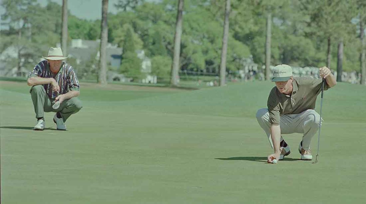 Greg Norman watches as Davis Love III lines up a putt at the 1995 Masters