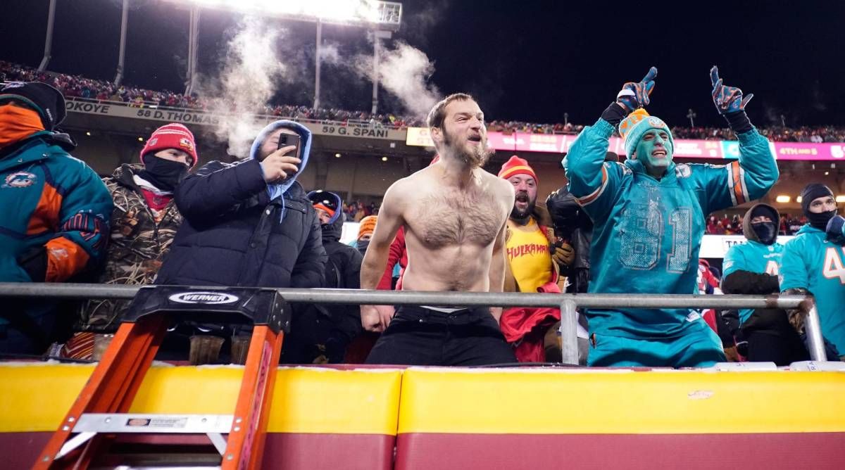 Fans of the Kansas City Chiefs and Miami Dolphins cheer on in the cold during a playoff game.