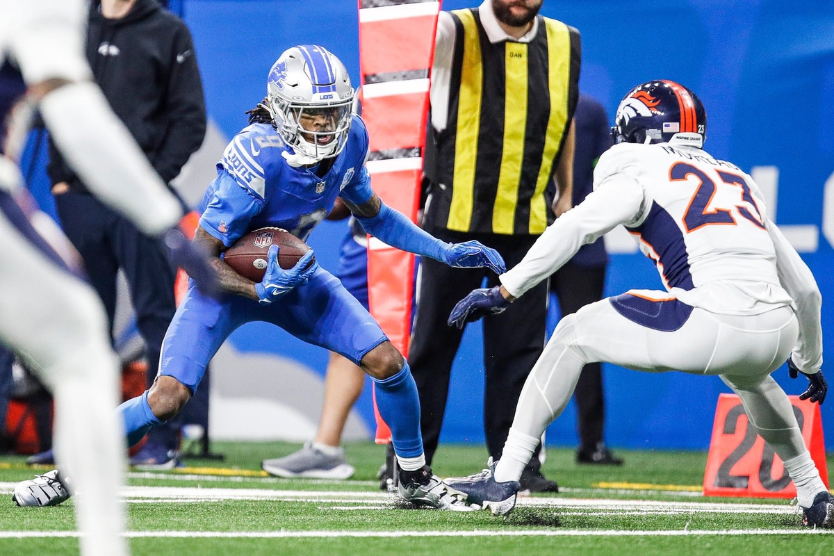 Detroit Lions wide receiver Jameson Williams (9) runs after a reception against Denver Broncos cornerback Fabian Moreau (23) during the first half at Ford Field in Detroit on Saturday, Dec. 16, 2023.