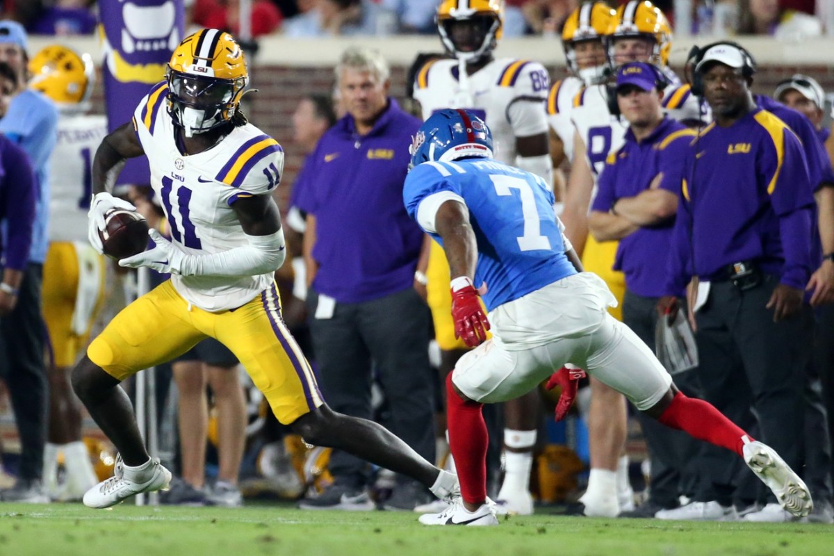 Sep 30, 2023; Oxford, Mississippi, USA; LSU Tigers wide receiver Brian Thomas Jr. (11) runs after a catch as Mississippi Rebels defensive back Deantre Prince (7) attempts to make the tackle during the second half at Vaught-Hemingway Stadium. Mandatory Credit: Petre Thomas-USA TODAY Sports  