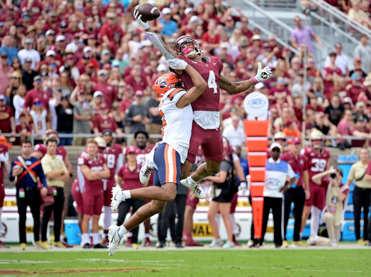 Oct 14, 2023; Tallahassee, Florida, USA; Florida State Seminoles wide receiver Keon Coleman (4) catches a pass over Syracuse Orange defensive back Jason Simmons Jr. (6) during the first quarter at Doak S. Campbell Stadium. Mandatory Credit: Melina Myers-USA TODAY Sports  