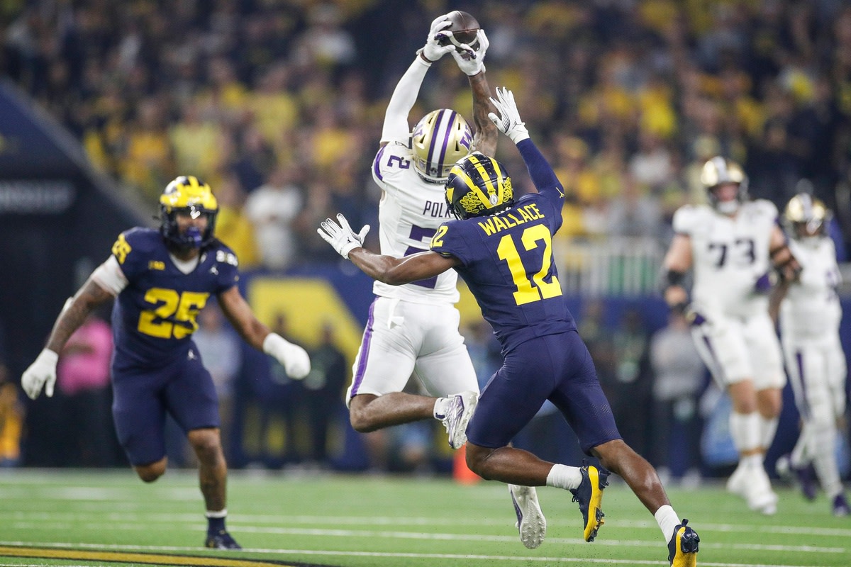 Washington wide receiver Ja'Lynn Polk makes a catch against Michigan defensive back Josh Wallace during the first half of the national championship game at NRG Stadium in Houston, Texas on Monday, Jan. 8, 2024.  