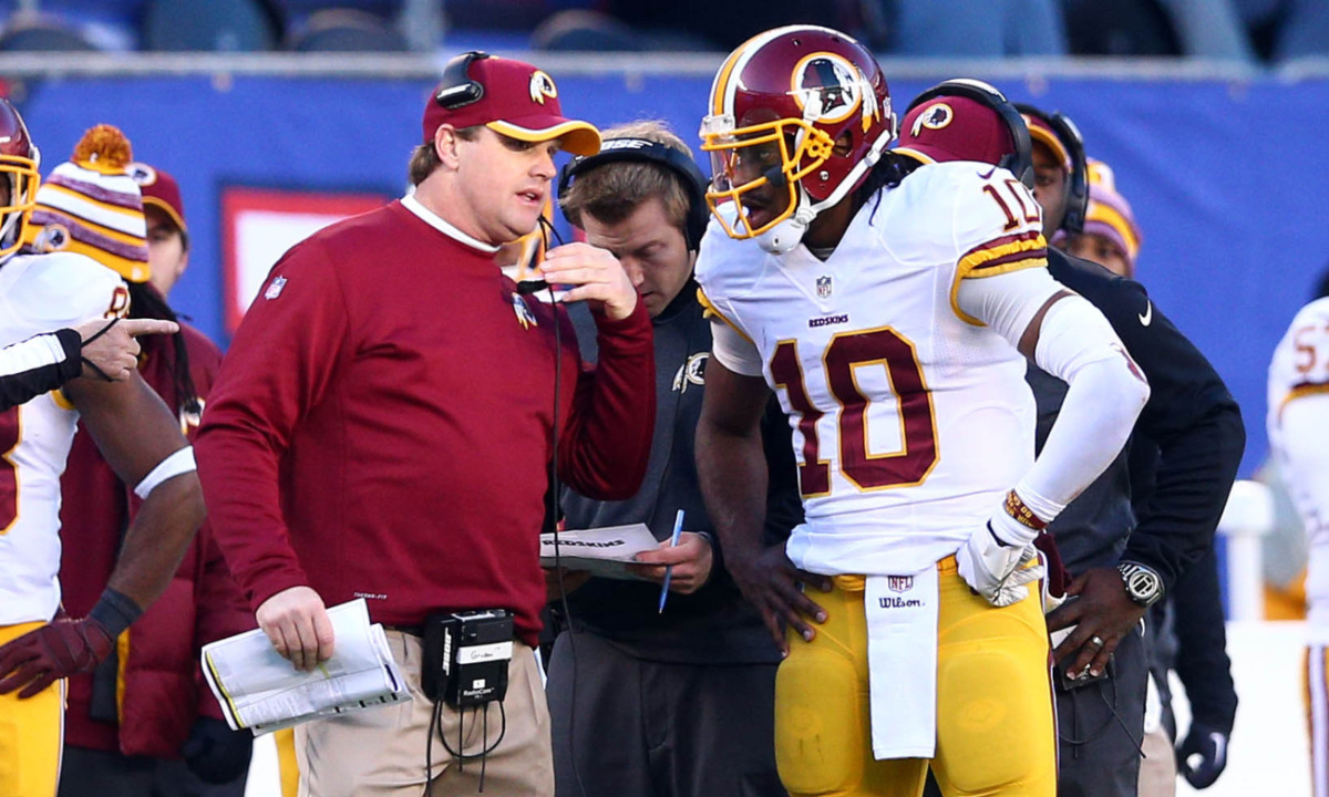 Dec 14, 2014; East Rutherford, NJ, USA; Washington Redskins head coach Jay Gruden talks with quarterback Robert Griffin III (10) during the third quarter of a game against the New York Giants at MetLife Stadium.