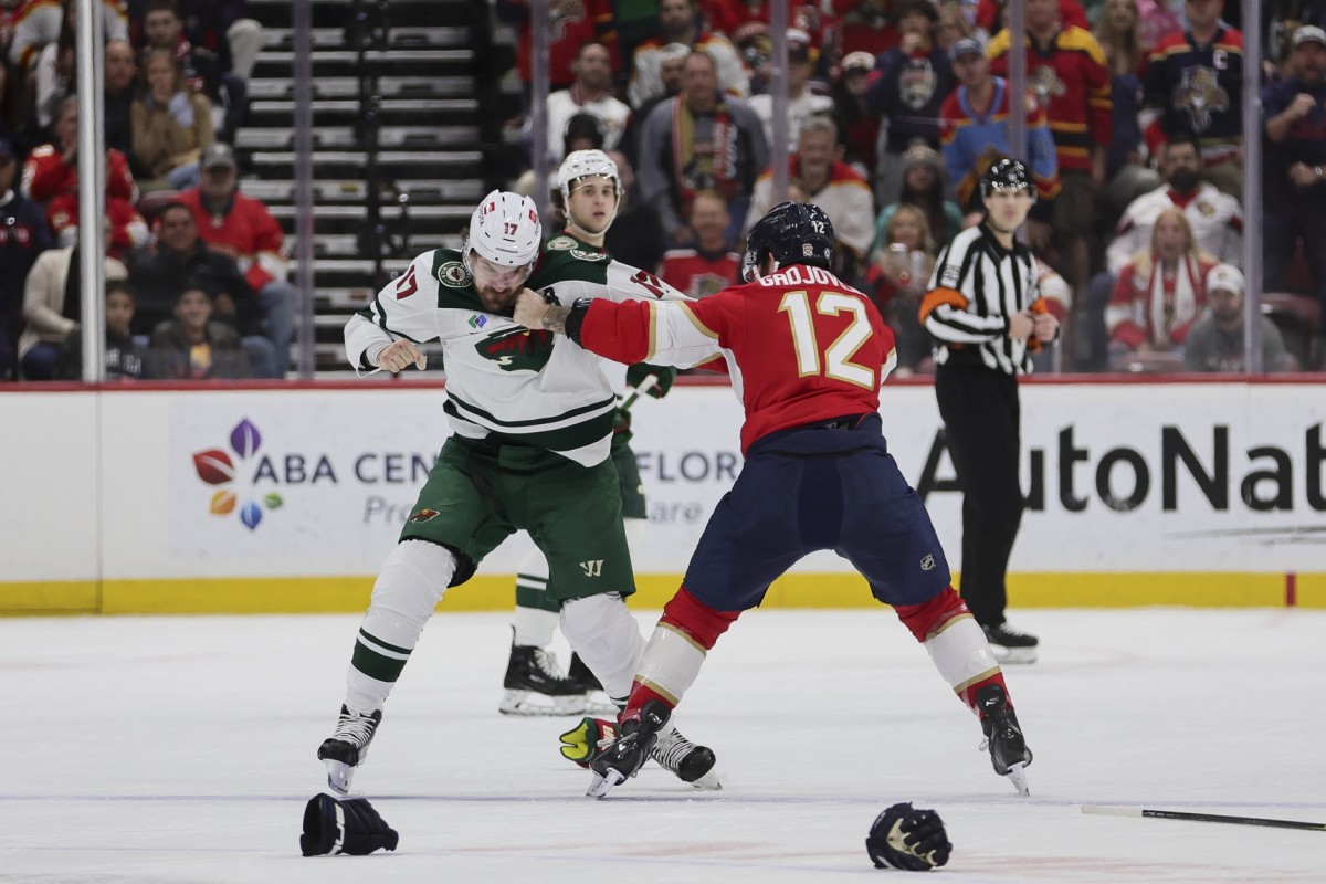Jan 19, 2024; Sunrise, Florida, USA; Minnesota Wild left wing Marcus Foligno (17) and Florida Panthers left wing Jonah Gadjovich (12) fight during the first period at Amerant Bank Arena.