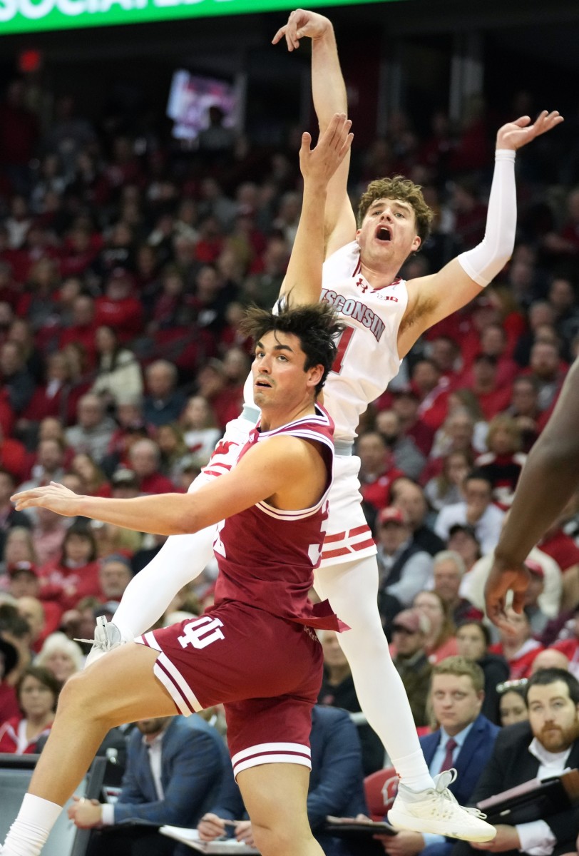 Wisconsin Badgers guard Max Klesmit (11) scores a three point basket and is fouled by Indiana Hoosiers guard Trey Galloway (32) during the second half at the Kohl Center.