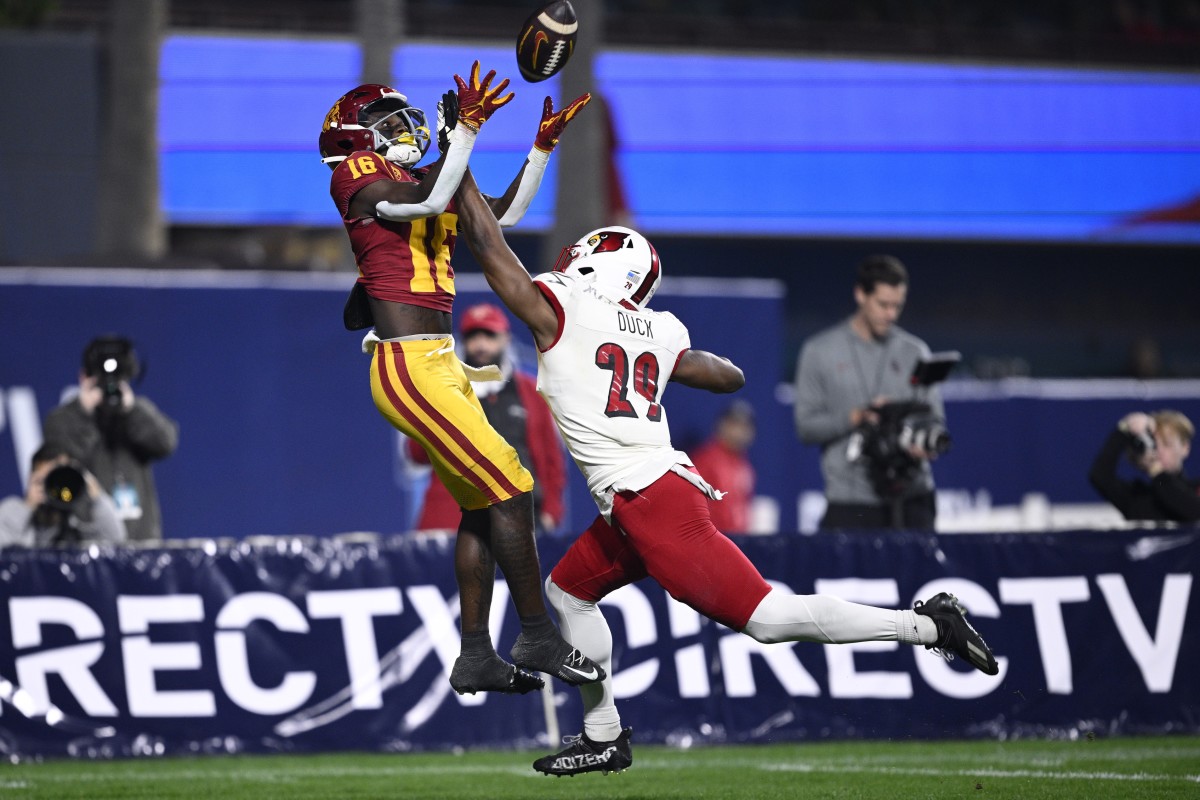 Dec 27, 2023; San Diego, CA, USA; USC Trojans wide receiver Tahj Washington (16) catches a touchdown over Louisville Cardinals defensive back Storm Duck (29) during the first half at Petco Park. Mandatory Credit: Orlando Ramirez-USA TODAY Sports  