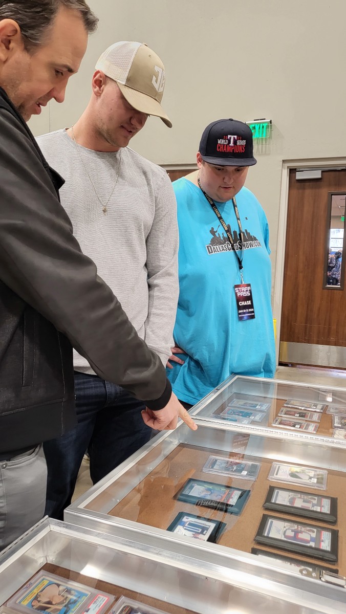 Texas Rangers All-Star third baseman Josh Jung, center, surveyed some of the items at the Dallas Card Show in Allen on Saturday before signing autographs.