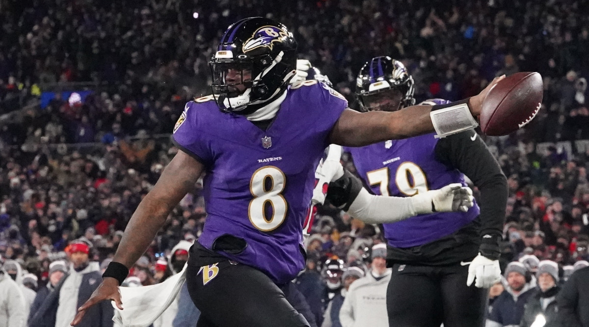 Baltimore Ravens quarterback Lamar Jackson runs while stretching the ball over the end zone.