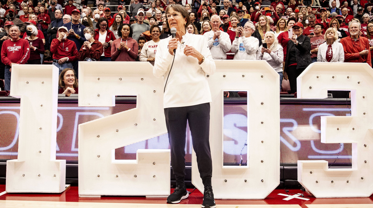 Stanford head coach Tara VanDerveer stands in front of the numbers 1203 to celebrate her become the all-time winningest coach in college basketball.