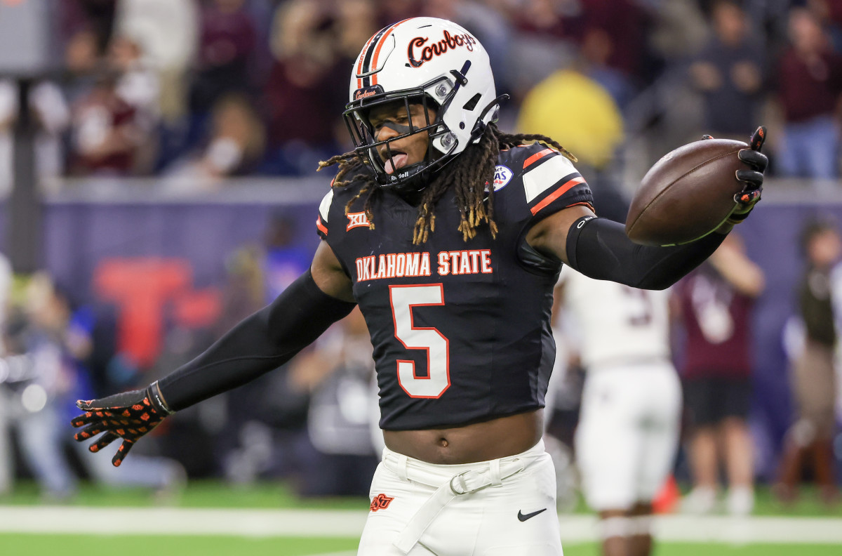 Dec 27, 2023; Houston, TX, USA; Oklahoma State Cowboys safety Kendal Daniels (5) celebrates his interception against the Texas A&M Aggies in the second half at NRG Stadium. Mandatory Credit: Thomas Shea-USA TODAY Sports