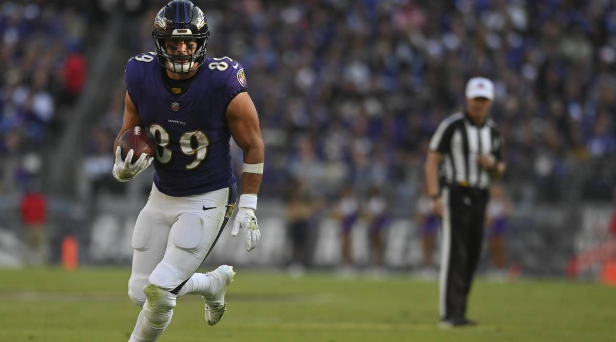 Baltimore Ravens tight end Mark Andrews runs with a ball in a game.
