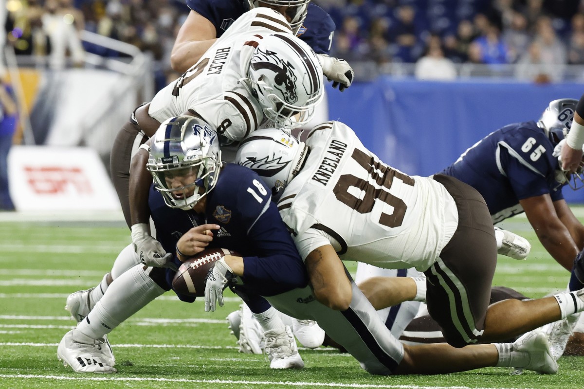 Dec 27, 2021; Detroit, MI, USA; Nevada Wolf Pack quarterback Nate Cox (16) is sacked by Western Michigan Broncos defensive lineman Marshawn Kneeland (94) and defensive lineman Ralph Holley (8) in the first half during the 2021 Quick Lane Bowl at Ford Field. Mandatory Credit: Rick Osentoski-USA TODAY Sports  