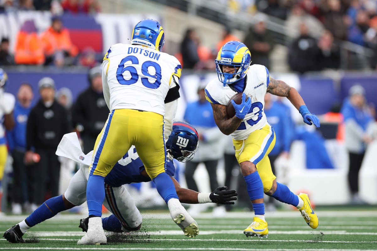 Dec 31, 2023; East Rutherford, New Jersey, USA; Los Angeles Rams running back Kyren Williams (23) scores a rushing touchdown as Los Angeles Rams guard Kevin Dotson (69) blocks New York Giants linebacker Bobby Okereke (58) during the second half at MetLife Stadium.