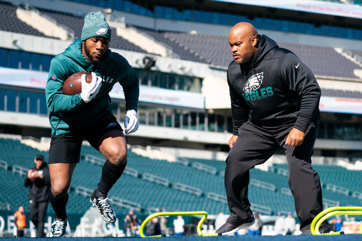 Eagles running back Miles Sanders warms up in front of assistant coach Duce Staley