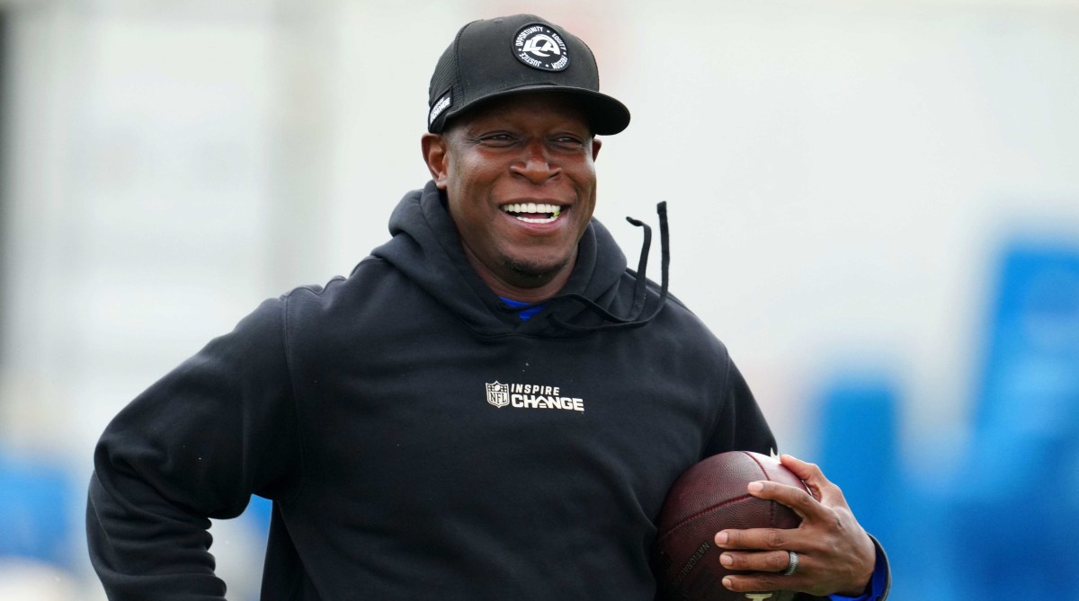 Raheem Morris smiles with a football in hand