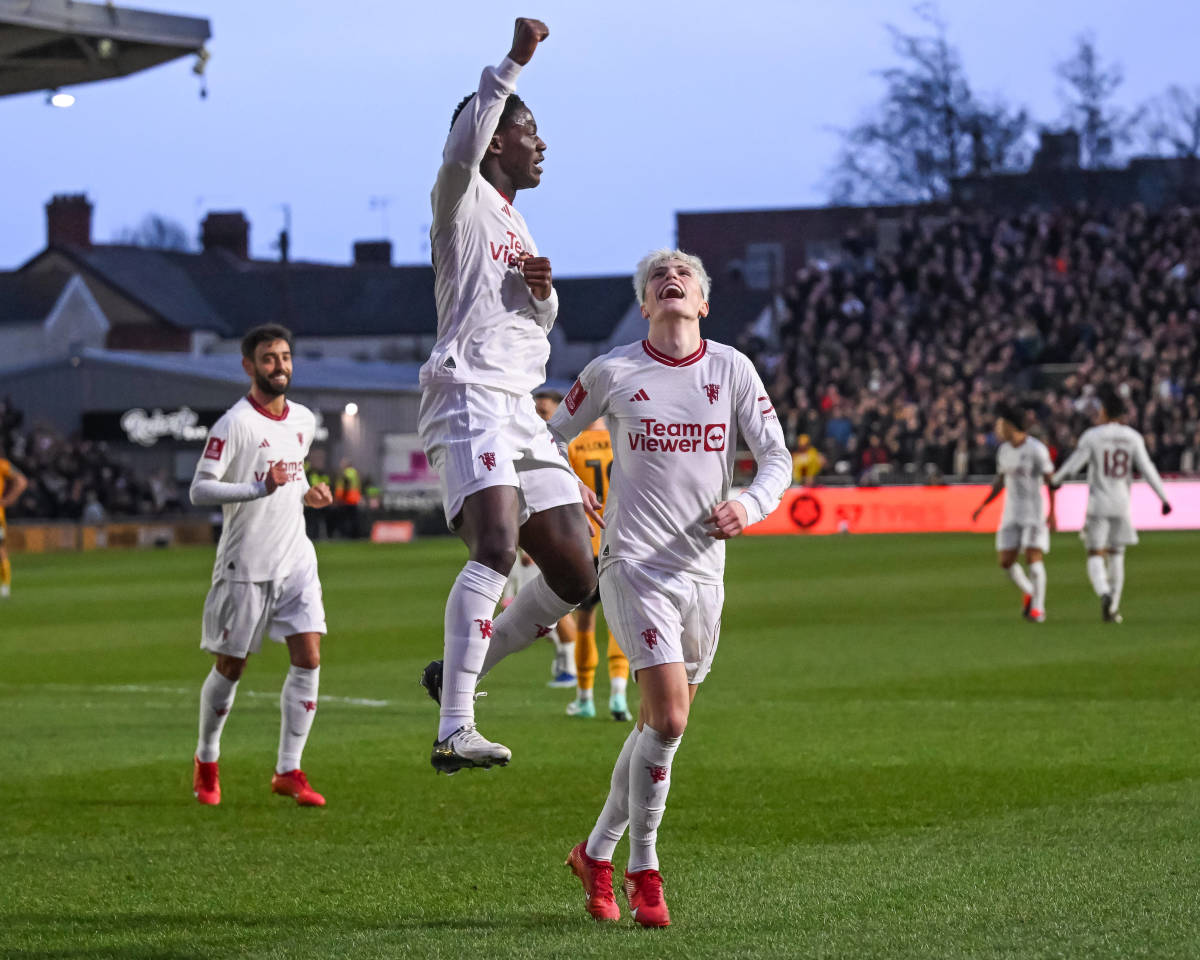 Kobbie Mainoo pictured jumping and punching the air after scoring the first goal of his Manchester United career in a 4-2 win at Newport County in January 2024