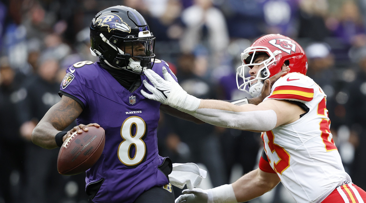 Ravens quarterback Lamar Jackson, left, prepares to throw the ball whil Chiefs linebacker Drue Tranquill tries to sack him.