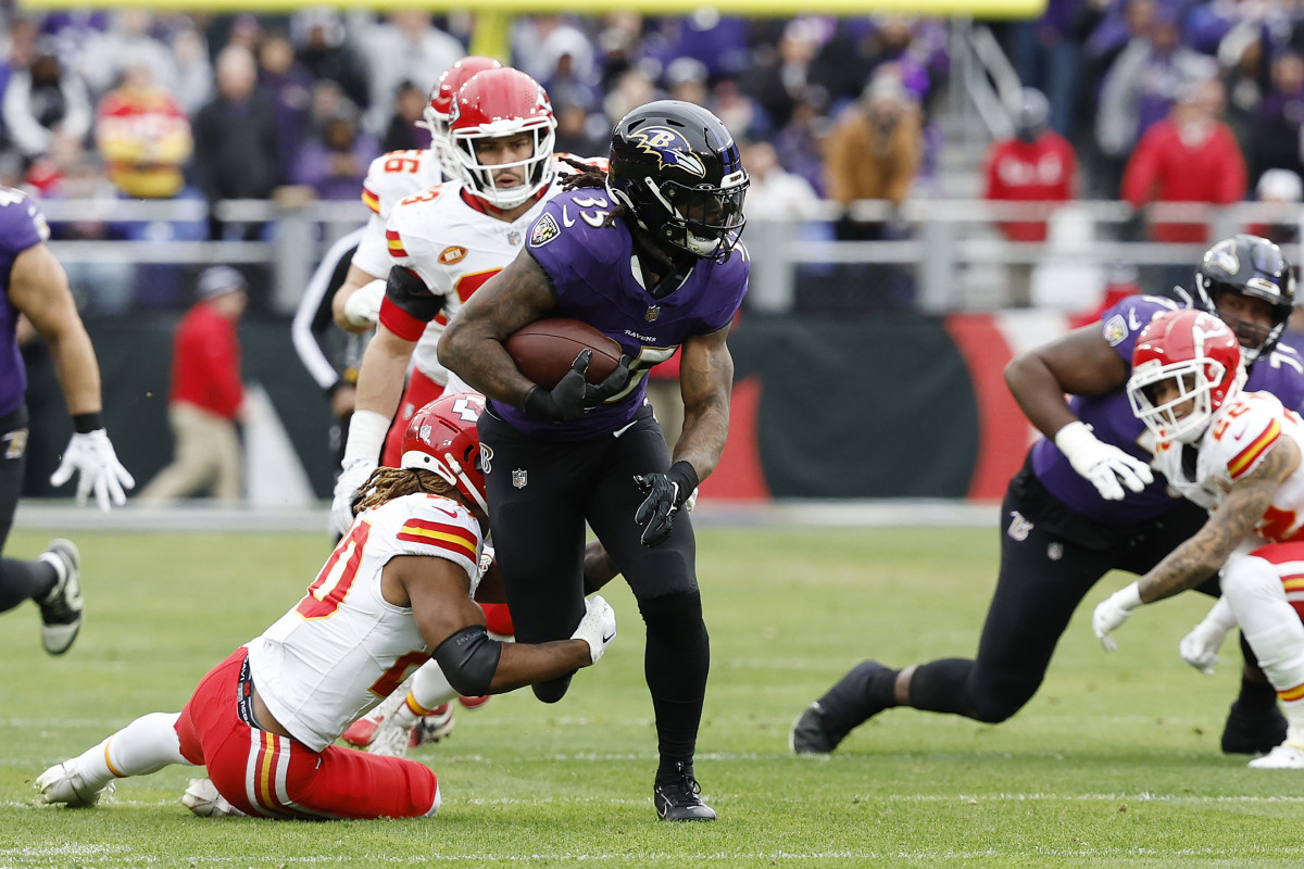 Jan 28, 2024; Baltimore, Maryland, USA; Baltimore Ravens running back Gus Edwards (35) runs with the ball as Kansas City Chiefs safety Justin Reid (20) defends during the first half in the AFC Championship football game at M&T Bank Stadium. Mandatory Credit: Geoff Burke-USA TODAY Sports