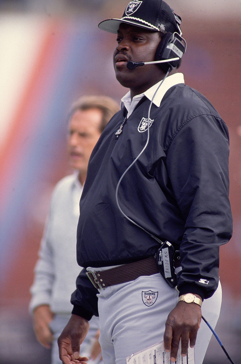 Art Shell stands on the sideline with a headset on